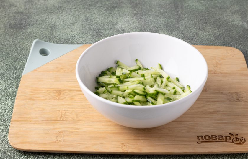 1. Этап. Овощной салат Дыхание Дракона: Огурцы порежьте соломкой, добавьте пару щепоток соли и сахара, перемешайте. Оставьте на 10 минут. После отожмите от жидкости, которая выделилась.