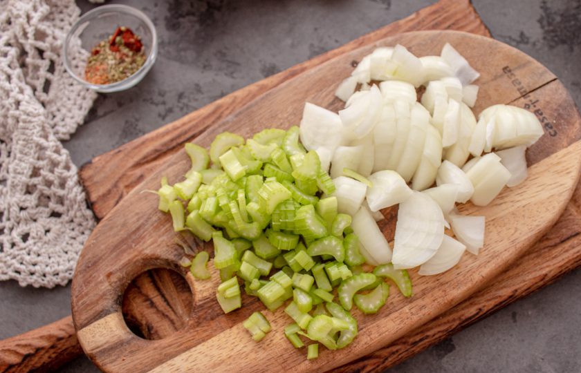 1. Этап. Лобио с сельдереем: Лук очистите и нарежьте кубиком. Сельдерей промойте, обсушите и нарежьте мелко. В сковороде нагрейте масло, выложите лук и сельдерей и жарьте пару минут, до мягкости.