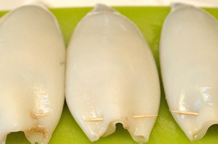 1. Этап. Кальмары, фаршированные курицей и грибами: Теперь нам нужно очистить и промыть тушки кальмаров, вытереть их насухо и нафаршировать приготовленной начинкой, закрепить отверстие зубочисткой. Не забывайте, что кальмары во время приготовления сжимаются, поэтому их следует фаршировать так, чтобы оставалось в запасе свободное место.