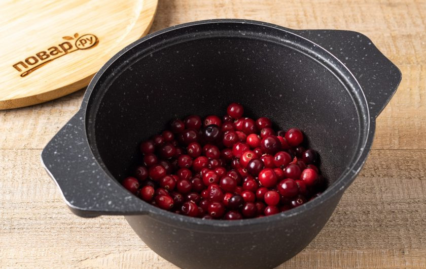 1. Этап. Соус из клюквы на зиму: Переложите ягоду в кастрюлю с толстым дном, влейте воду и поставьте на средний огонь.
