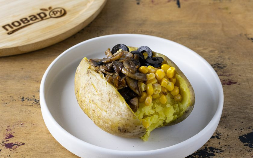 1. Этап. Картофель Кумпир: Выложите начинку в картофель жареный лук с грибами, кукурузу и нарезанные маслины. Сверху посыпьте свежей зеленью и полейте майонезом.