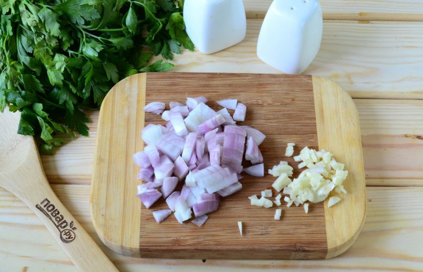 1. Этап. Кабачки, фаршированные куриной грудкой: Лук порежьте кубиком, чеснок порежьте мелко ножом или выдавите через пресс для чеснока. Отправьте лук вместе с чесноком в сковороду с небольшим количеством растительного масла и жарьте, пока чеснок не начнет отдавать свой аромат, а лук не станет прозрачным.