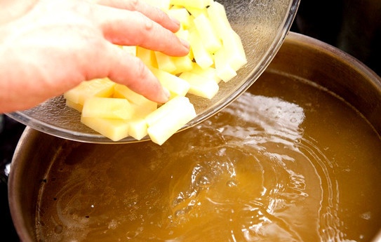 1. Этап. Щи из соленой капусты: Пока овощи тушатся, вытаскиваем из сваренного бульона косточки и закладываем картошку. Также, можно положить перчик горошком, лавровый лист и специи.