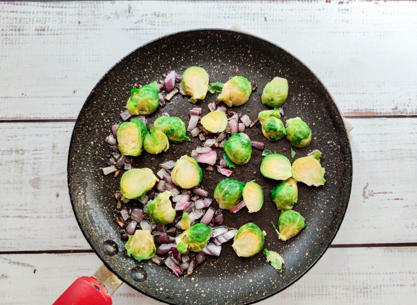 1. Этап. Омлет с брюссельской капустой: В хорошо разогретую сковороду с растительным маслом выложите мелко нарезанный красный лук, брюссельскую капусту и обжарьте все до золотистого цвета.