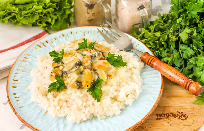 1. Этап. Рис с мидиями в сливочном соусе: Выложите отварной рис на тарелку, сверху выложите мидии в сливочном соусе и подайте блюдо к столу, украсив свежей зеленью.