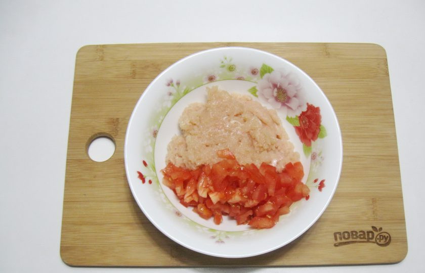 1. Этап. Перцы фаршированные курицей в духовке: Помидор помойте и нарежьте мелкими кубиками. Добавьте к филе.