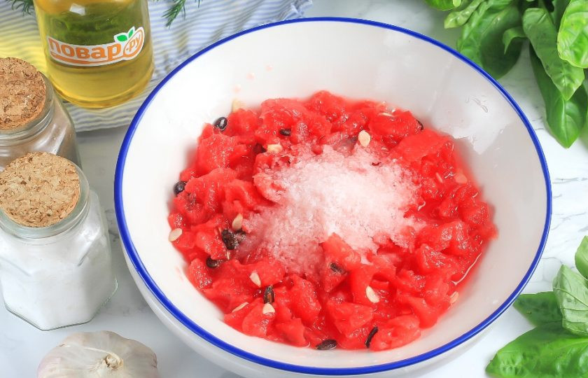 1. Этап. Малосольные огурцы в арбузе: Половину арбузной мякоти раздавите в миске, всыпьте соль и влейте воду. Тщательно перемешайте.