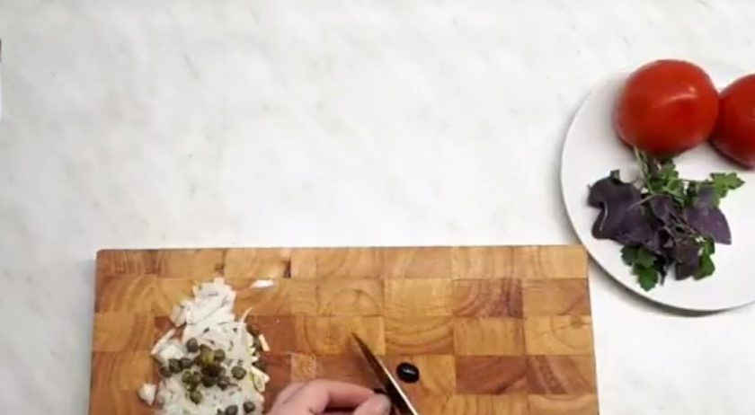 1. Этап. Тилапия запеченная (простой рецепт): 2. Лук и помидоры нарежьте тонкими пластинками, чеснок измельчите ножом. Добавьте каперсы. Нарежьте маслины, зелень. Филе рыбы нарежьте, посолите и поперчите, отправьте в духовку и запеките в течение 10 минут до полуготовности.