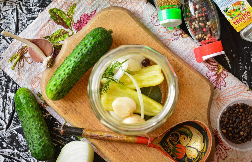 Огурцы маринованные с кетчупом на зиму 1. Этап. Огурцы маринованные с кетчупом на зиму: Выложите на дно чистых простерилизованных банок специи — чеснок, кусочки репчатого лука, болгарского перца для аромата, горошины черного перца, лавровый лист, веточки укропа.