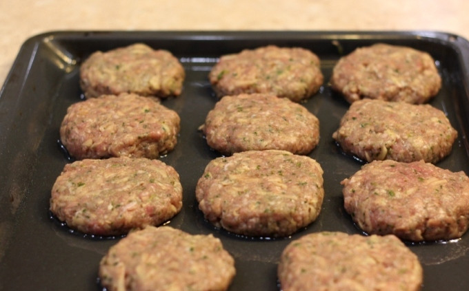 1. Этап. Котлеты, запеченные в духовке: Формируем из приготовленного фарша небольшие котлетки и выкладываем их на противень, смазанный растительным маслом.