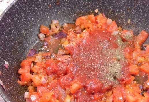 1. Этап. Горячая закуска из тунца с томатами: К обжаренным овощам добавить протертые томаты. Посолить, поперчить, приправить травами. Тушить под крышкой на медленном огне 5 минут.