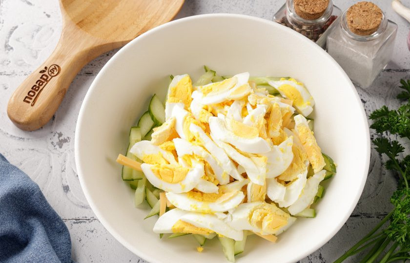 1. Этап. Салат с кукурузой, огурцом и сыром: Яйца очистите, разрежьте пополам и так же нарежьте соломкой.