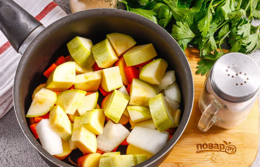 1. Этап. Овощной суп-пюре для детей: Промойте кабачок в воде, срежьте хвостики. Используйте молодой плод без плотной кожуры и семян внутри. Нарежьте половину кабачка средними кубиками, а половину луковицы — мелкими. Добавьте нарезки в емкость.