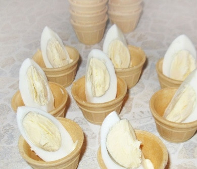 1. Этап. Тарталетки с черной икрой: 3. Заранее отварите и остудите яйца. Нарежьте их на четвертинки и каждую отдельную часть поставьте в тарталетку.