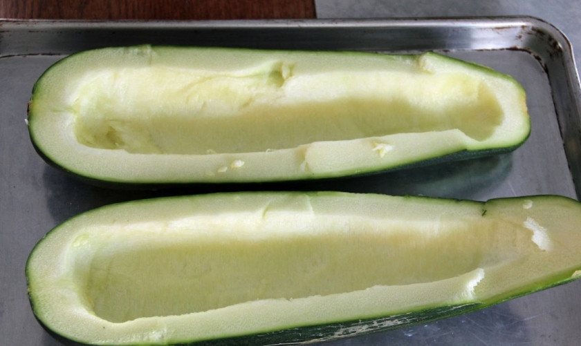 1. Этап. Говядина с кабачками в духовке: Пропустите говядину через мясорубку или возьмите готовый фарш. Смешайте его с мелко порубленным луком и чесноком, посолите и поперчите. Обжарьте на сковороде в течение 10 минут. Разрежьте кабачок вдоль и удалите семена и немного мякоти, чтобы освободить место для начинки.