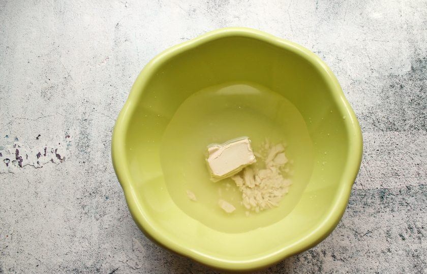 1. Этап. Ватрушки с маскарпоне: В теплую воду раскрошите дрожжи, добавьте сахар и соль. Все хорошо перемешайте до растворения.