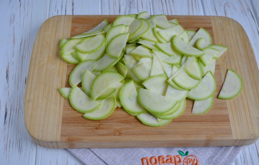 1. Этап. Острая закуска из кабачков: У кабачка срежьте хвостик и попку. Сам кабачок нарежьте кружочками или полукружочками максимально тонко. Это легко сделать с помощью овощечистки.