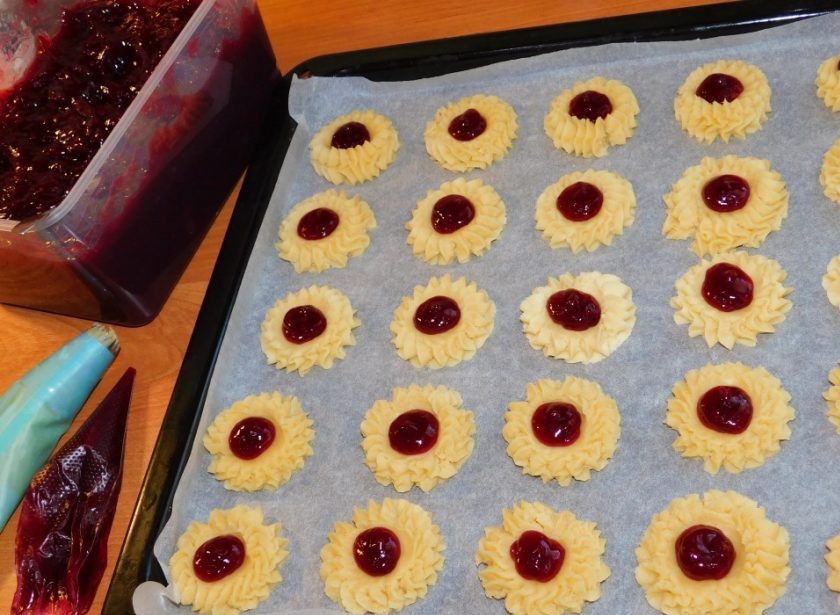 1. Этап. Песочное печенье с конфитюром: С помощью кондитерского мешка отсадите печенье. В центре сделайте углубление и выложите немного конфитюра. Поставьте в духовку при 200 градусах минут на 15-20.