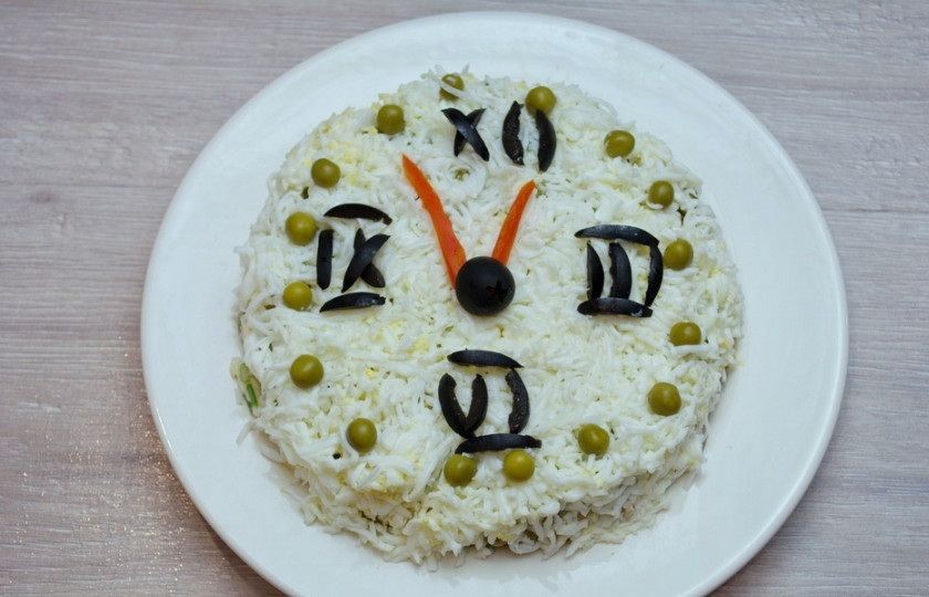 1. Этап. Новогодний салат Куранты: 8. Из оливок и моркови сделайте цифры на циферблате и стрелки. Горошком я очертила круг, чтобы придать салату законченность.