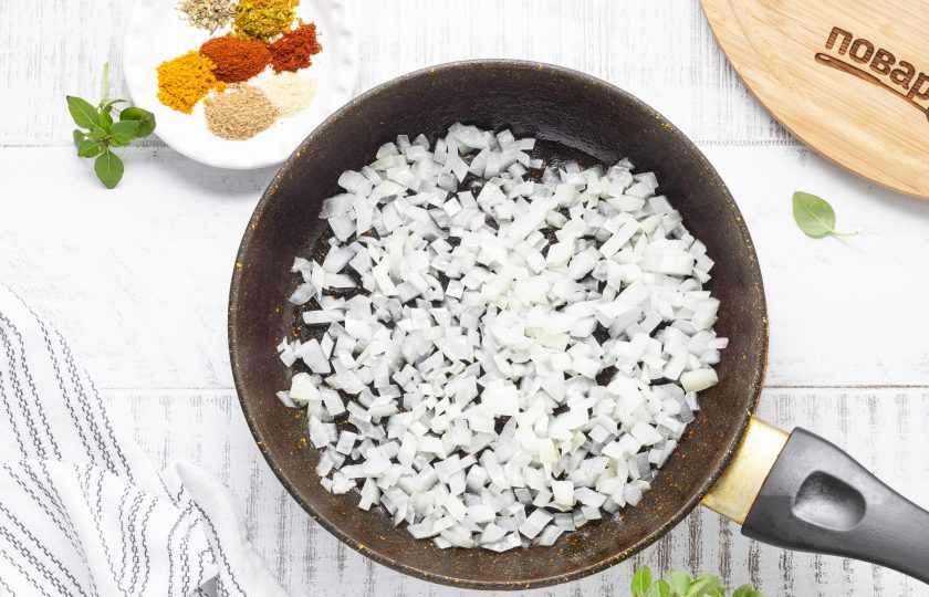 1. Этап. Фаршированные помидоры с киноа: Для начинки разогрейте сковороду на среднем огне, обжарьте нарезанный кубиками репчатый лук.