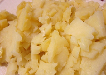 1. Этап. Окрошка на кефире и минеральной воде: 1. Перед тем, как приготовить окрошку на кефире и минеральной воде, сварите картошку в мундире. Охладите. Почистите от шкурки. Мелко нарежьте мякоть.