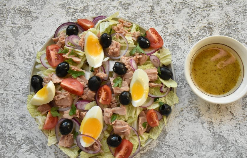 1. Этап. Салат с капустой, помидорами и тунцом: Поверх капустных листьев разложите кусочки консервированного тунца, дольки отварных яиц, помидоров черри, маслины, измельченную зелень петрушки. Заправьте салат непосредственно перед подачей.