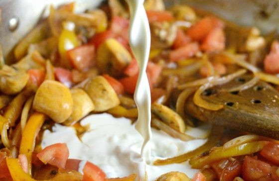 1. Этап. Каджунская паста с курицей: 6. Затем влейте сливки. Перемешайте ингредиенты. Доведите соус до кипения.