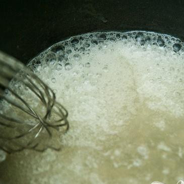 1. Этап. Пудинг с хурмой: 7. За 10 минут до окончания приготовления пудинга сделать соус. Вскипятить воду в небольшой кастрюле. Взбить сахар и муку вместе, добавить смесь в кипящую воду и взбить венчиком. Варить соус в течение 5 минут, снять с огня и перемешать с ванильным экстрактом.