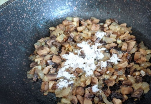 1. Этап. Гнёзда, фаршированные тунцом и шампиньонами: Кладём шампиньоны на сковороду, обжариваем 5 минут на среднем огне. Посыпаем мукой, перемешиваем.