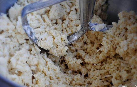 1. Этап. Лимонно-кокосовые пирожные: 1. Предварительно разогреть духовку до 175 градусов. Смазать сливочным маслом металлическую форму для выпекания. В большой миске перемешать вместе муку, кокосовую стружку, сахарную пудру и соль. Добавить сливочное масло и взбивать электрическим миксером на низкой скорости.