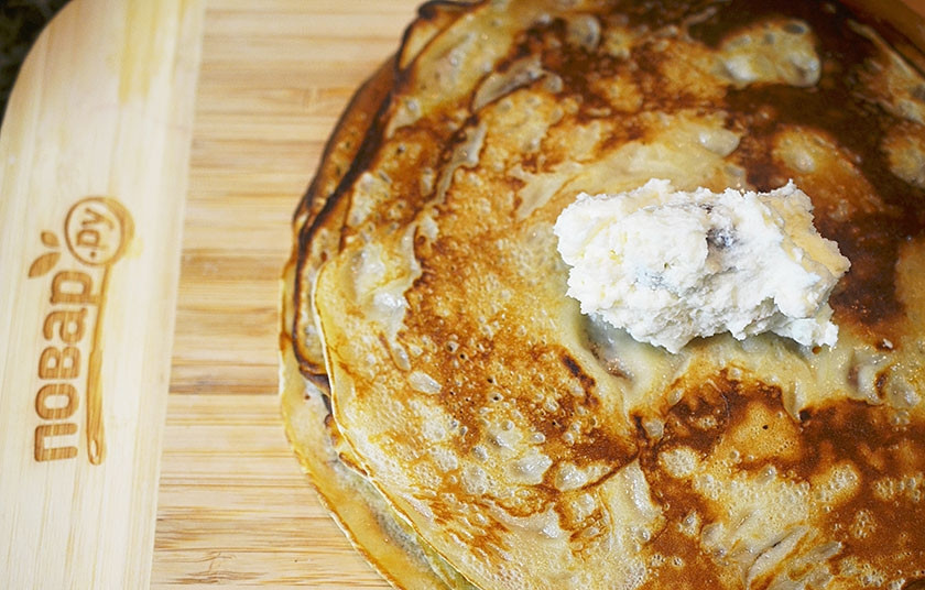 1. Этап. Творожные блины с кунжутом и изюмом: 7. Положите блин кунжутом вниз, выложите ложку начинки и заверните.