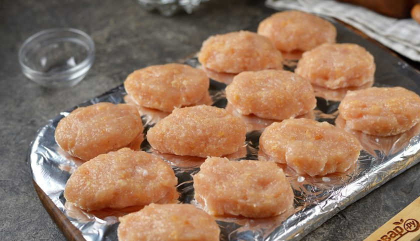 1. Этап. Куриные наггетсы без масла: Слегка смочите руки в воде, сформируйте небольшие заготовки из фарша, выложите их на разделочную доску, замотанную в фольгу, отправьте в морозильную камеру минут на 20.