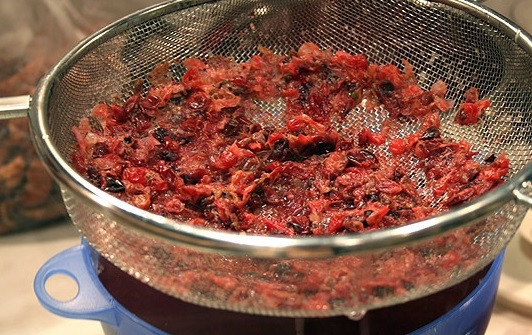 1. Этап. Кисель из свежих ягод: Вскипятите 3 литра воды, закиньте в неё жмых, варите 20 минут. Процедите смесь через сито, затем выбросьте оставшуюся кожуру. Далее поставьте её на огонь до закипания, отлив 1 стакан жидкости отдельно. Как закипит, всыпьте сахар.