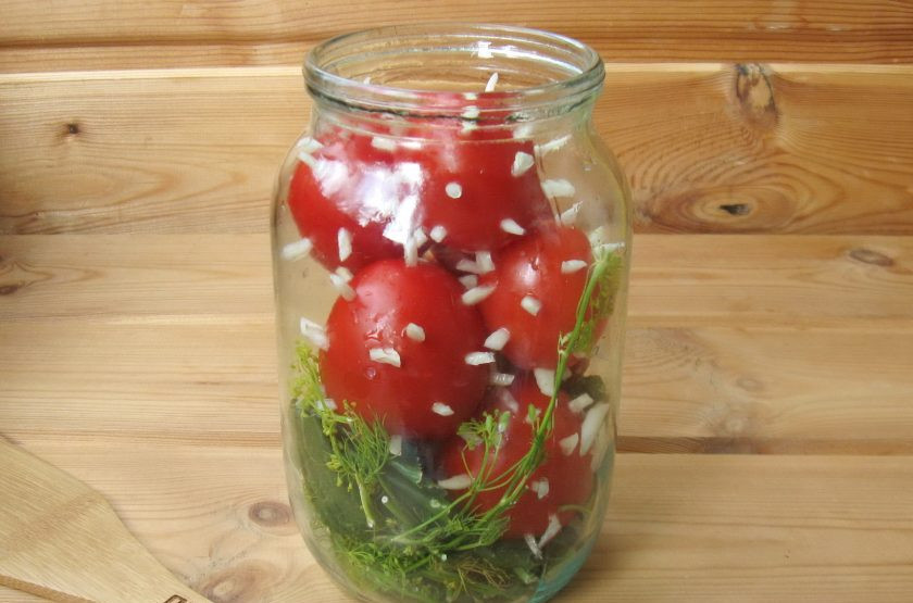 1. Этап. Помидоры Ежики: Выложите помидоры с чесноком в банку. Содержимое банки залейте кипящей водой, банку накройте стерилизованной крышкой и дайте постоять 20 минут. После воду слейте в кастрюлю и опять доведите до кипения. Второй раз залейте помидоры кипятком и опять дайте постоять 20 минут. Второй раз слейте воду в кастрюлю и доведите её до кипения.