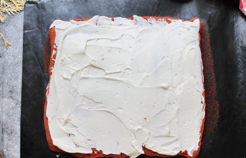 1. Этап. Рулет Красный бархат: Рулет разверните, снимите верхний пергамент и нанесите большую часть крема на поверхность бисквита. Сверните бисквит с кремом в плотный рулет.