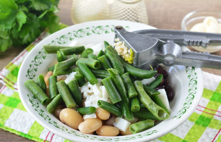 1. Этап. Салат Три фасоли: Добавьте в салат зеленую фасоль выдавите чеснок.