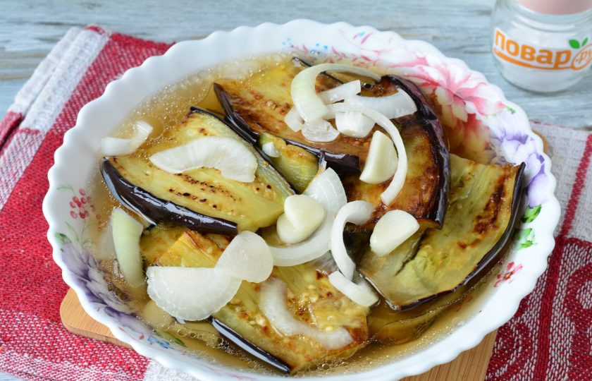 1. Этап. Маринованные баклажаны с чесноком и луком: Выкладывайте баклажаны слоями, пересыпая луком и чесноком. В конце залейте остывшим маринадом. Поставьте закуску в холодильник на 5-6 часов, чтобы баклажаны промариновались.