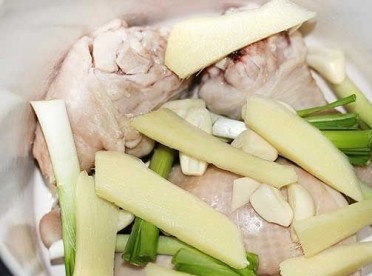 1. Этап. Суп Рамен: Выкладываем курицу в чистую кастрюлю, добавляем кусочки имбиря, белую часть от зеленого лука и зубчики чеснока.