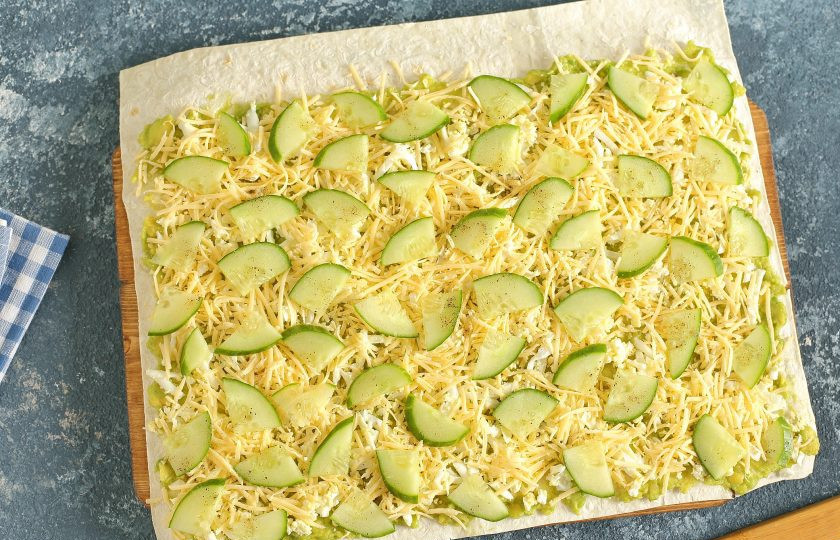 1. Этап. Диетические начинки для лаваша: Смажьте лаваш намазкой из авокадо, посыпьте сверху тертые яйца и сыр. Затем разложите огурец, посолите начинку и поперчите по вкусу. Сверните рулетом.