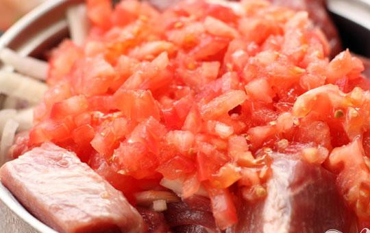 1. Этап. Шашлык из свинины с помидорами: 2. Берем помидоры, промываем их, делаем небольшой надрез (крестообразный) в нижней части помидора, погружаем помидоры на несколько минут в кипящую воду, и после того очищаем их от кожицы. Теперь нарезаем помидоры мелкими кусочками. Очищаем немного репчатого лука, полукольцами его нарезаем, добавляем к нему немного морской соли и руками обжимаем. Лук должен дать сок. Добавляем нарезанные лук и помидоры в мясо.