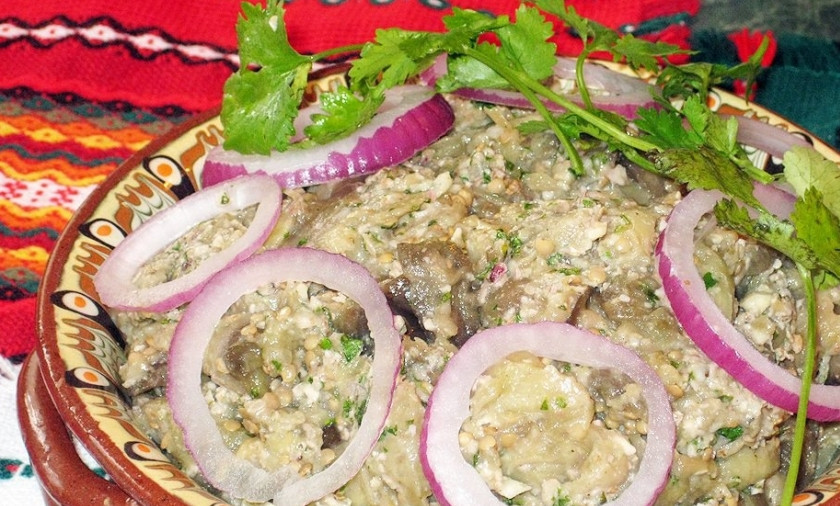 1. Этап. Пхали из баклажанов: Осталось подготовить блюдо к подаче. Для этого сверху выкладываем кольца лука и листики свежей зелени. При наличии граната можно насыпать сверху горсть гранатовых зерен, так блюдо будет выглядеть нарядно.