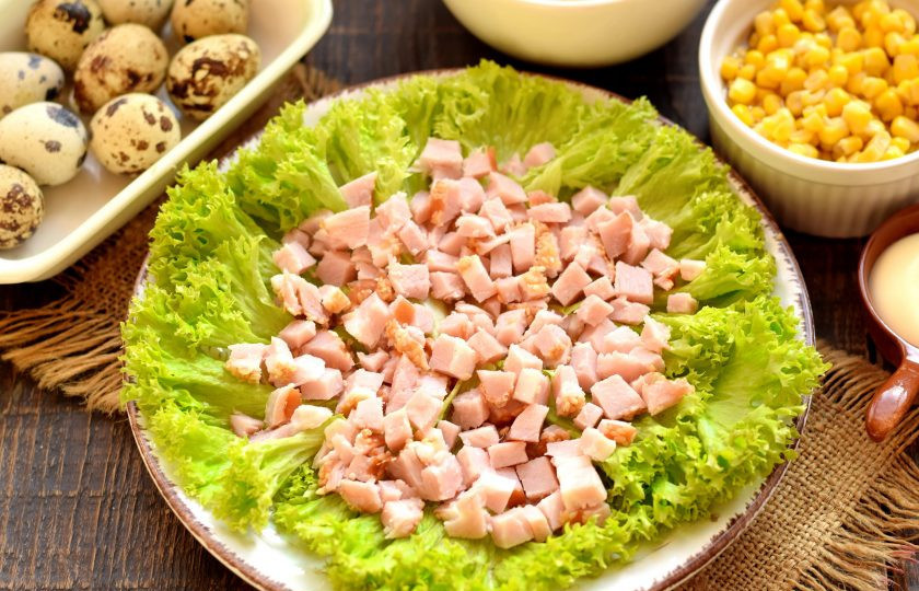 1. Этап. Салат Богатый маркиз: Листья салата ополосните, высушите, выложите по кругу на плоской тарелке для подачи. Ветчину нарежьте мелким кубиком, выложите на листья салата.
