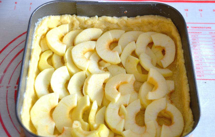 1. Этап. Яблочный пирог Восторг: Из большей части теста в любой форме для выпечки (силиконовой, металлической) сделайте основу для пирога с небольшими бортиками (примерно 2 см.), выложите ломтики яблок.