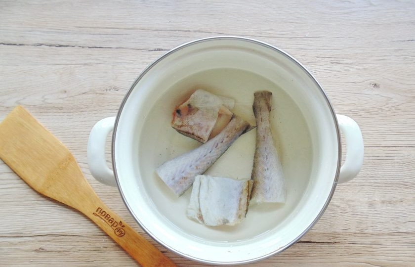 1. Этап. Уха из минтая с рисом: Нарежьте рыбу и выложите в кастрюлю. Затем налейте воду.