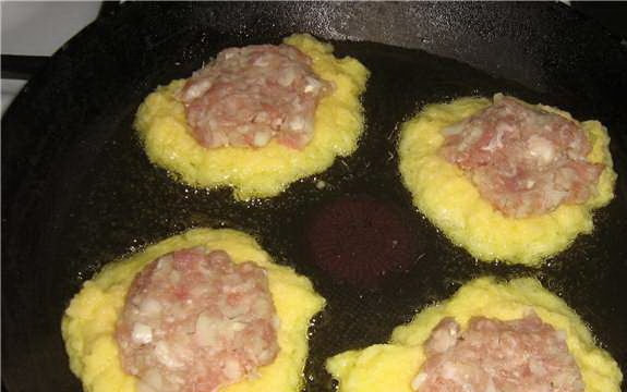 1. Этап. Драники с фаршем: В сковороду вылить растительное масло, раскалить. Ложкой выкладывать картофельную массу в виде оладьев. Сверху на каждый оладий положить лепешку из фарша. Сверху на фарш положить еще по ложке картофельной массы.