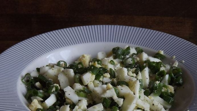 1. Этап. Пирожки с яйцом и зеленым луком: Пока тесто отдыхает, приготовьте начинку. Для этого отварите вкрутую куриные яйца, остудите их, очистите от скорлупы и нарубите кубиками. Добавьте к ним мелко нарезанный зеленый лук, соль и перец. Все тащательно перемешайте.