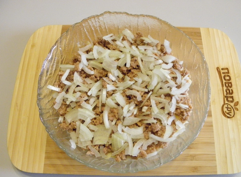 1. Этап. Салат Мимоза новогодний: Максимально мелко порежьте луковицу, ошпарьте ее кипятком, чтобы горечь ушла, распределите поверх рыбы.