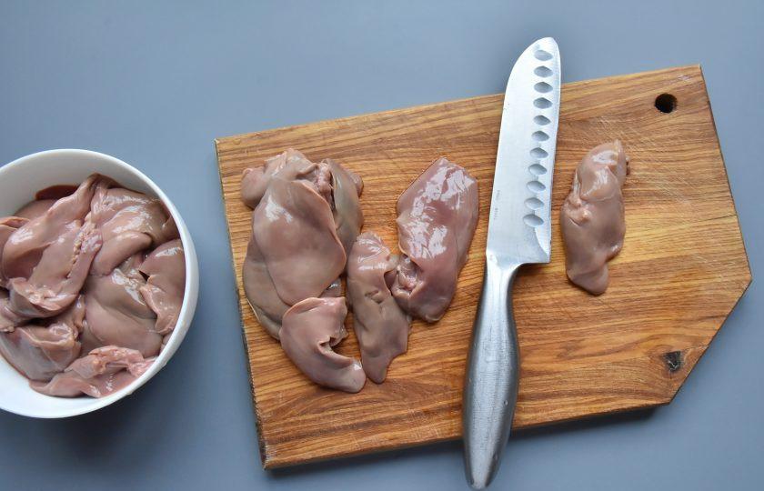 1. Этап. Куриная печень по-анжуйски: Каждый кусочек печени осмотрите на наличие желчного пузыря и протоков. При обнаружении удалите их. Срежьте лишний жир и соединительную ткань. Разрежьте крупные кусочки пополам.