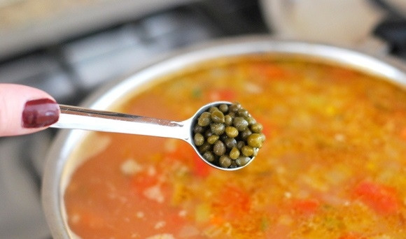 1. Этап. Перловый суп с солеными огурцами: 8. Нарежьте белую рыбу кусочками, добавьте в кастрюлю. Также добавьте каперсы, по вкусу посолите и поперчите. Варите 5-10 минут.