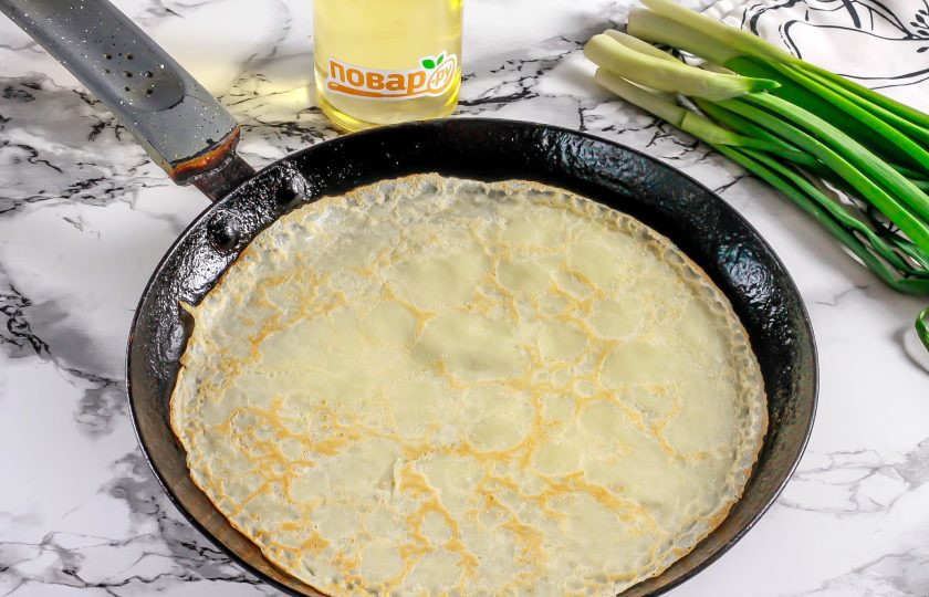 1. Этап. Блинчики со свиным сердцем: Прогрейте блинную сковороду на плите и смажьте ее в первый раз растительным маслом. Влейте немного теста и сформируйте круг. Обжарьте с каждой стороны по 1-2 минуты до румяности.